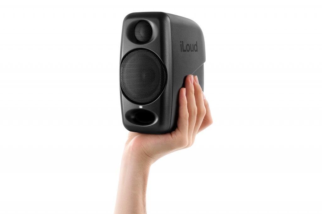 IK Multimedia iLoud Micro Monitor held in hand, demonstrating its ultra-compact size and portability, making it ideal for mobile production and on-the-go professional audio.