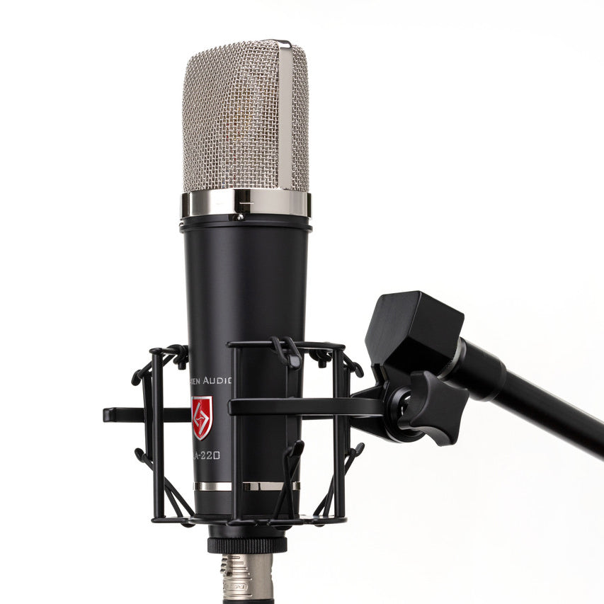 Lauten Audio LA-220 V2 Large-Diaphragm Condenser Microphone, side view mounted in its custom shockmount on a mic stand.