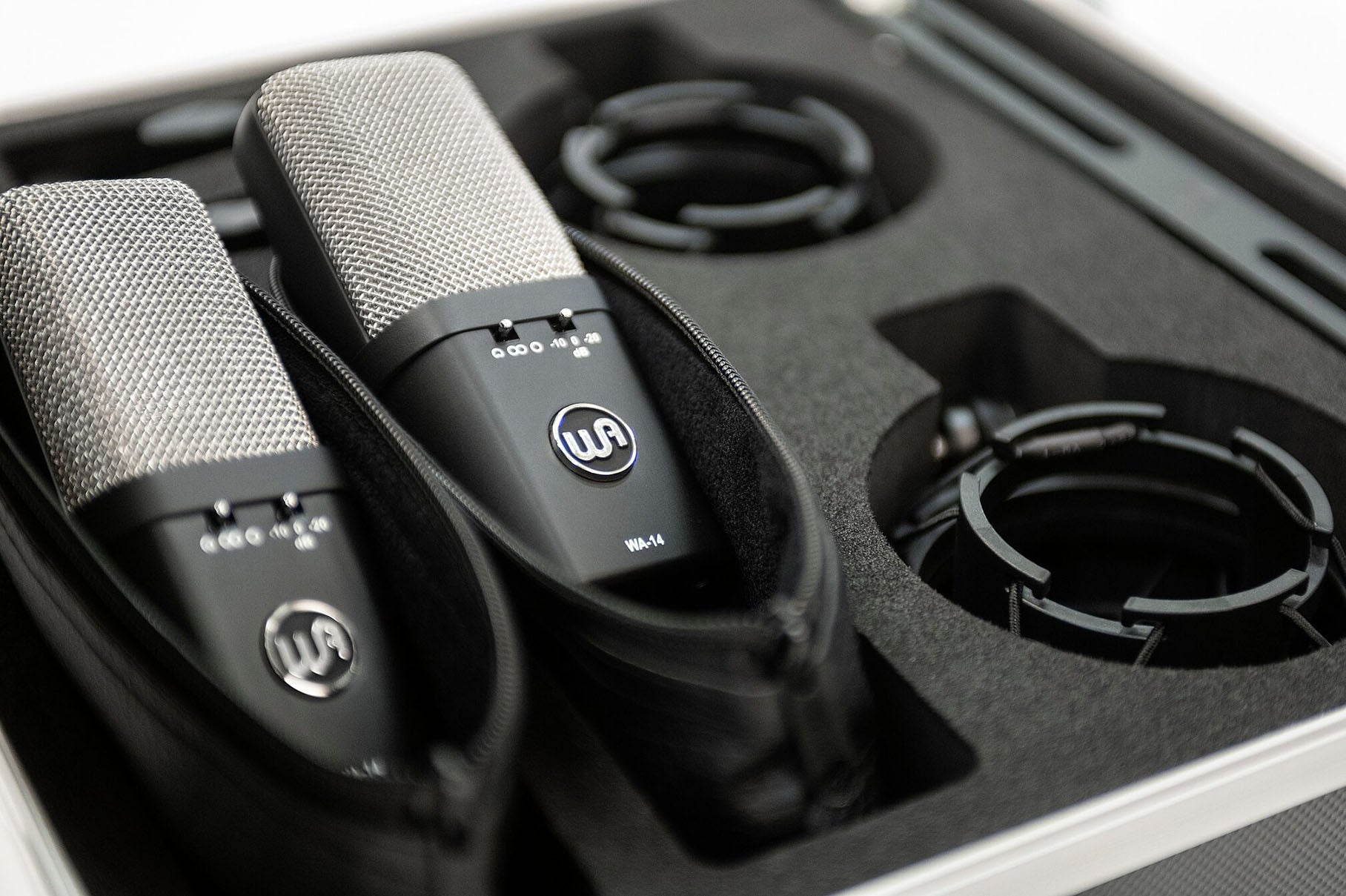 Stereo Pair of Warm Audio WA-14 Brass Capsule Large Diaphragm Condenser Microphones , close up view in carry case with mic pouches and shockmounts.